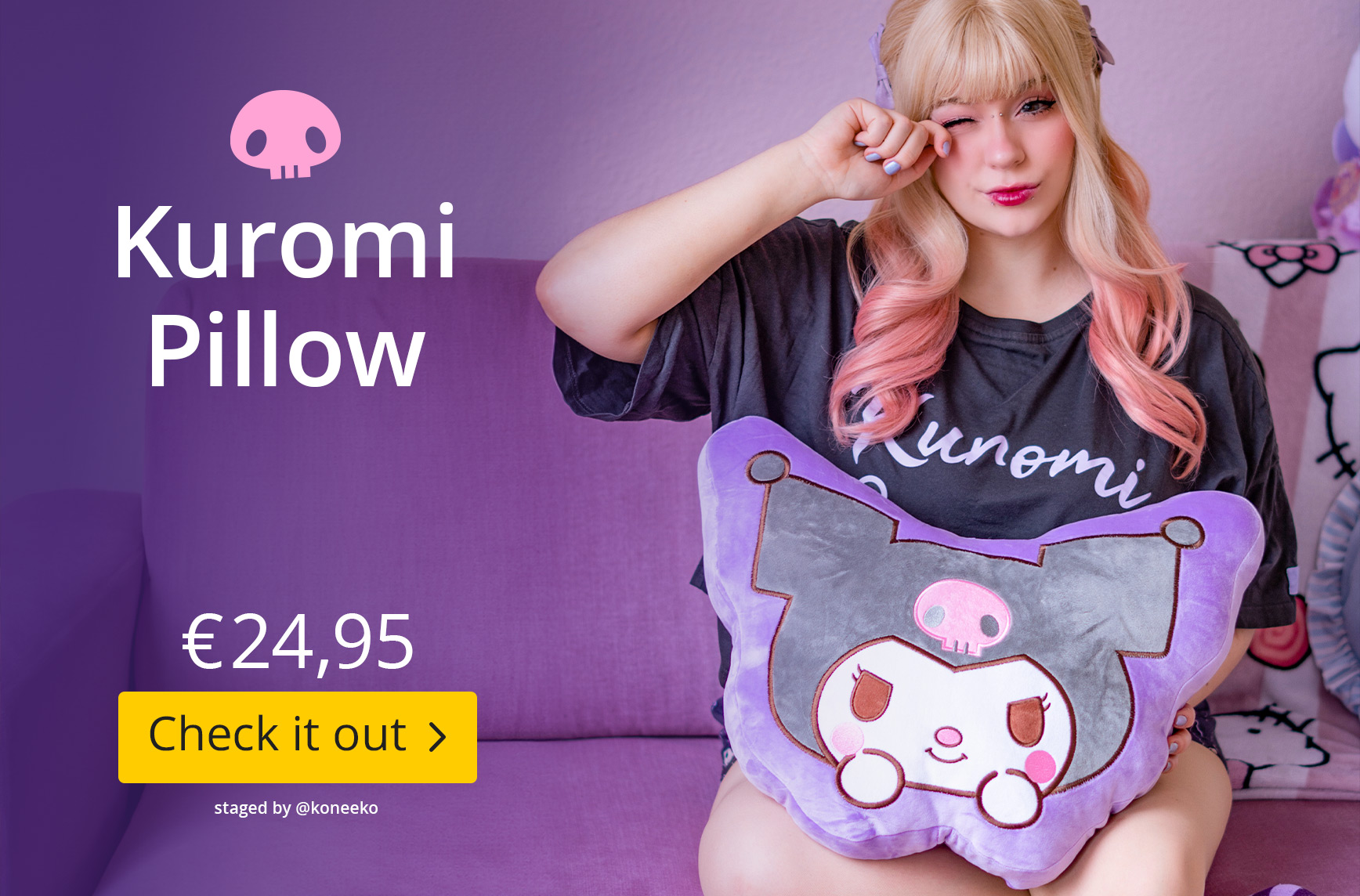 A person is sitting on a purple sofa, holding a large Kuromi soft toy cushion from the Hello Kitty and Friends range. More Kuromi accessories can be seen in the background. Kuromi pillow, €24.95, Check it out. Staged by @koneeko.