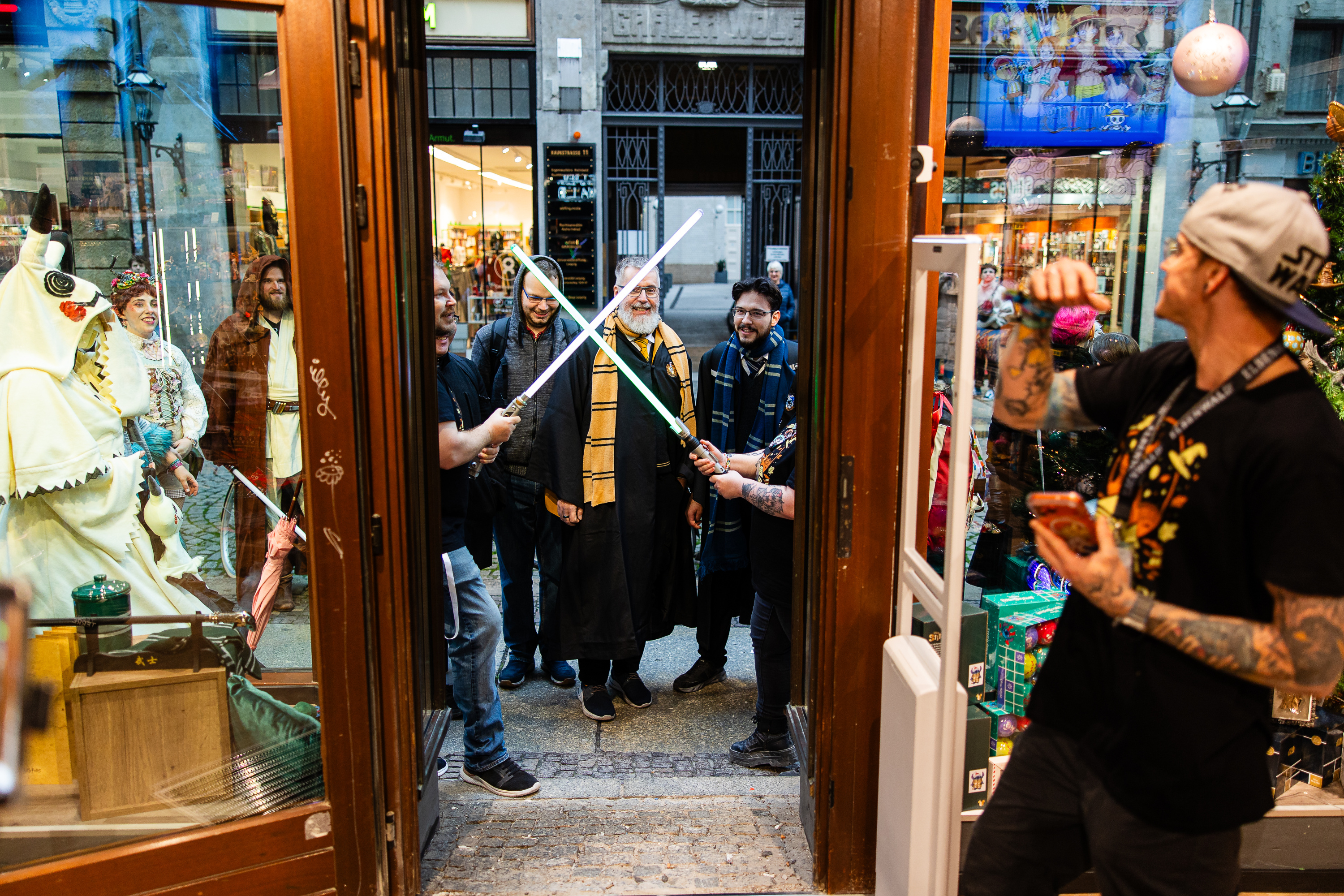 Fan in cosplay con spade laser sorridono davanti al negozio Elbenwald.