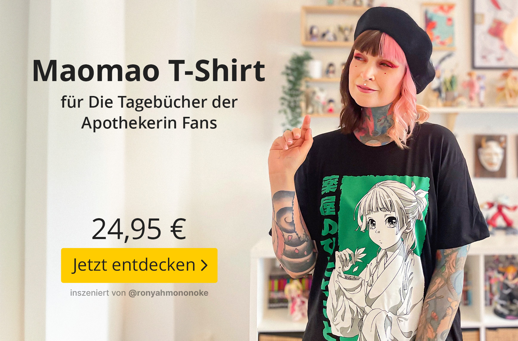 Person mit schwarzen und rosa Haaren sowie Tattoos trägt ein schwarzes Maomao T-Shirt aus Die Tagebücher der Apothekerin und posiert in einem hellen Zimmer mit Anime-Figuren im Hintergrund. Text im Bild: „Maomao T-Shirt für Die Tagebücher der Apothekerin 