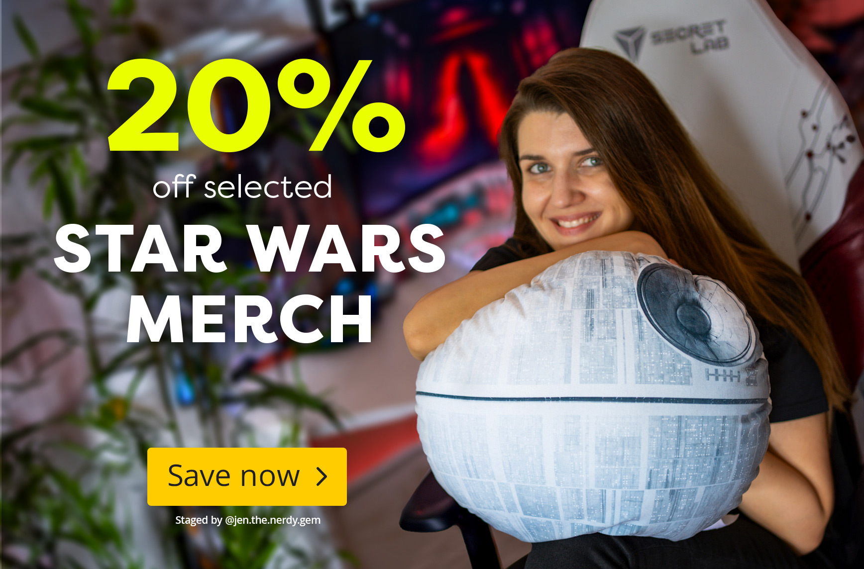 Person with long brown hair sitting on a gaming chair holding a round Death Star cushion from Star Wars. Text: “20% off selected Star Wars merch, Save now”.