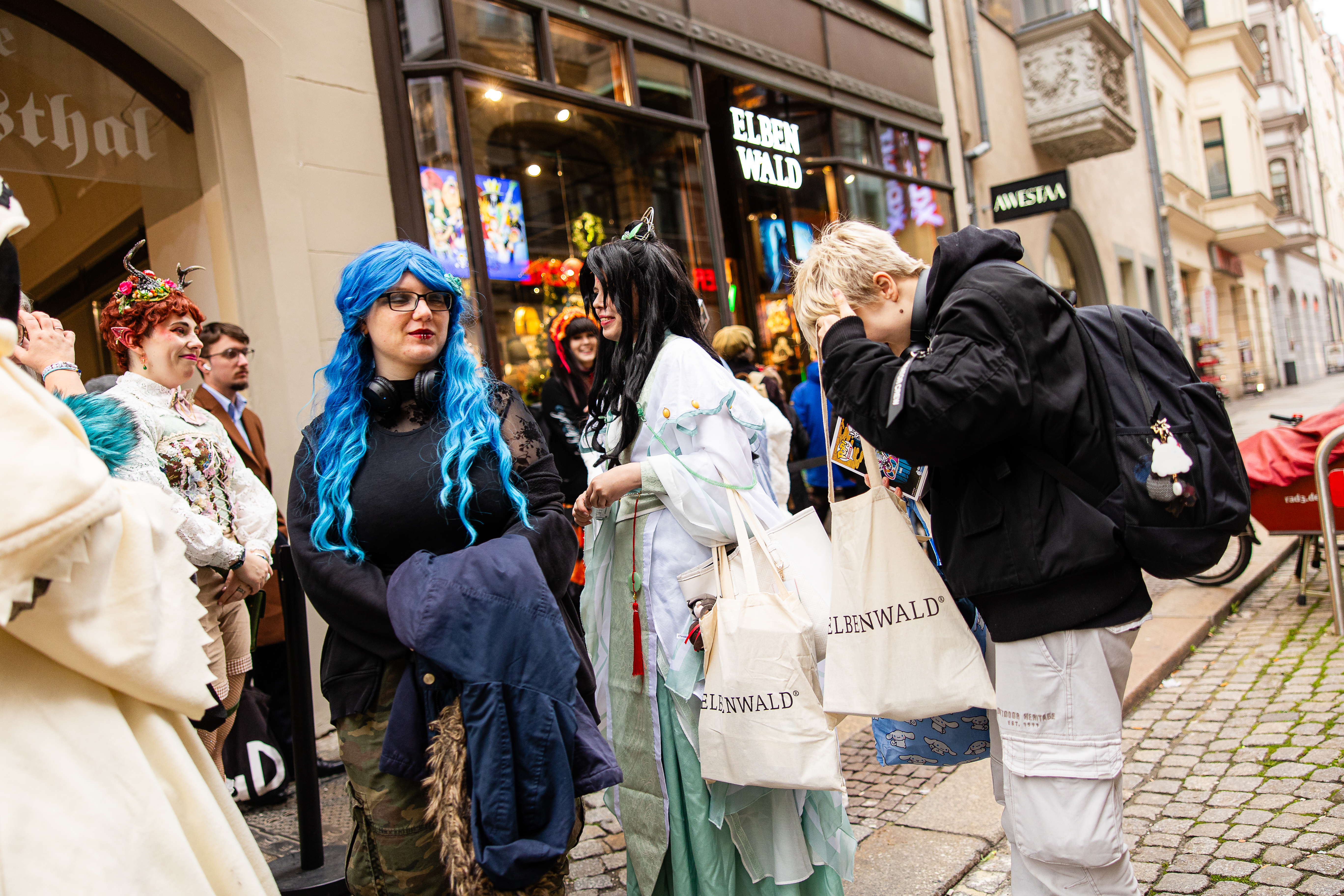Cosplayer parlano davanti al negozio, alcuni con borse Elbenwald.