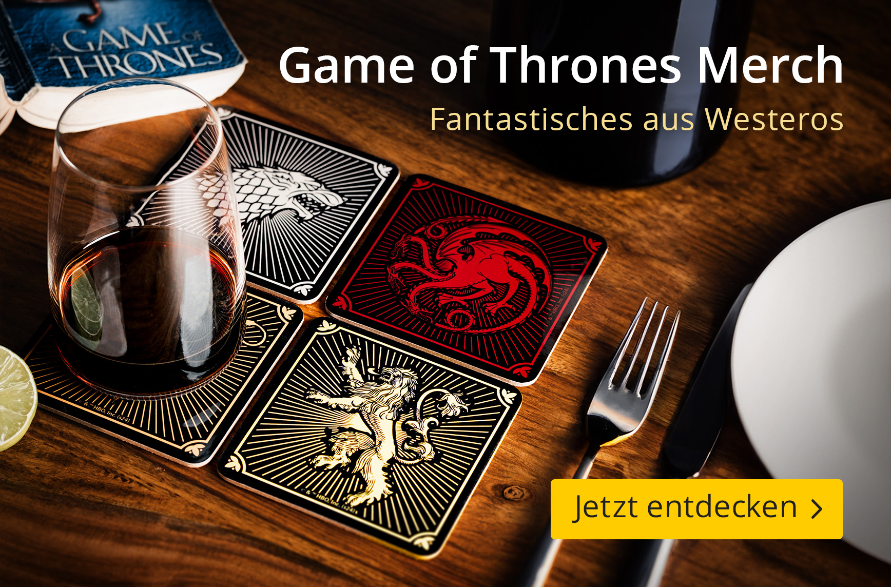 Vier quadratische Untersetzer mit den Wappen von Targaryen, Stark, Lennister und Graufreud liegen auf einem Holztisch, darauf ein Glas mit dunklem Getränk, daneben ein Besteckset und ein Game of Thrones Buch im Hintergrund. Text: Game of Thrones Merch, Fa