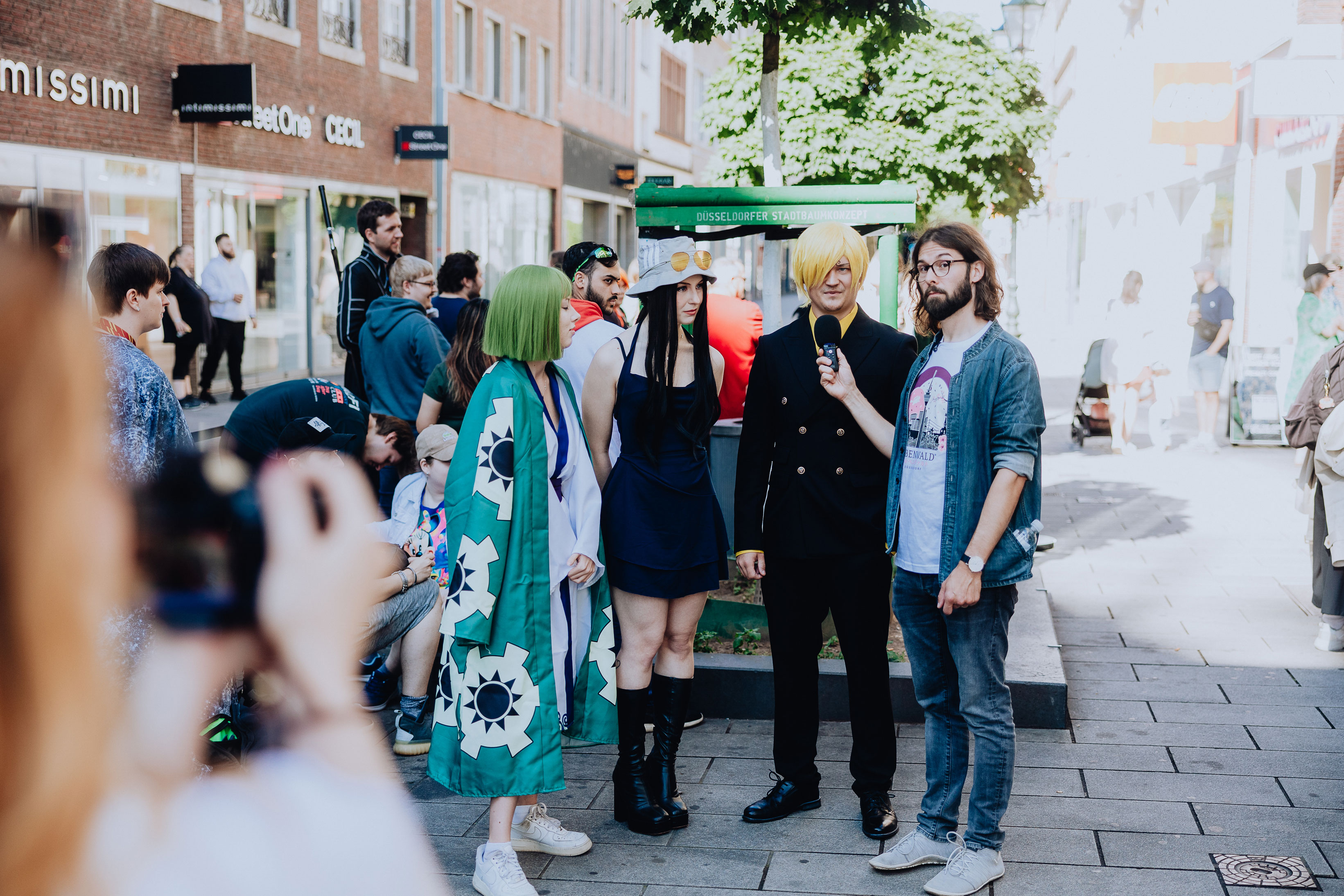 An Elbenwald employee interviews a group of cosplaying fans outside the Düsseldorf store.
