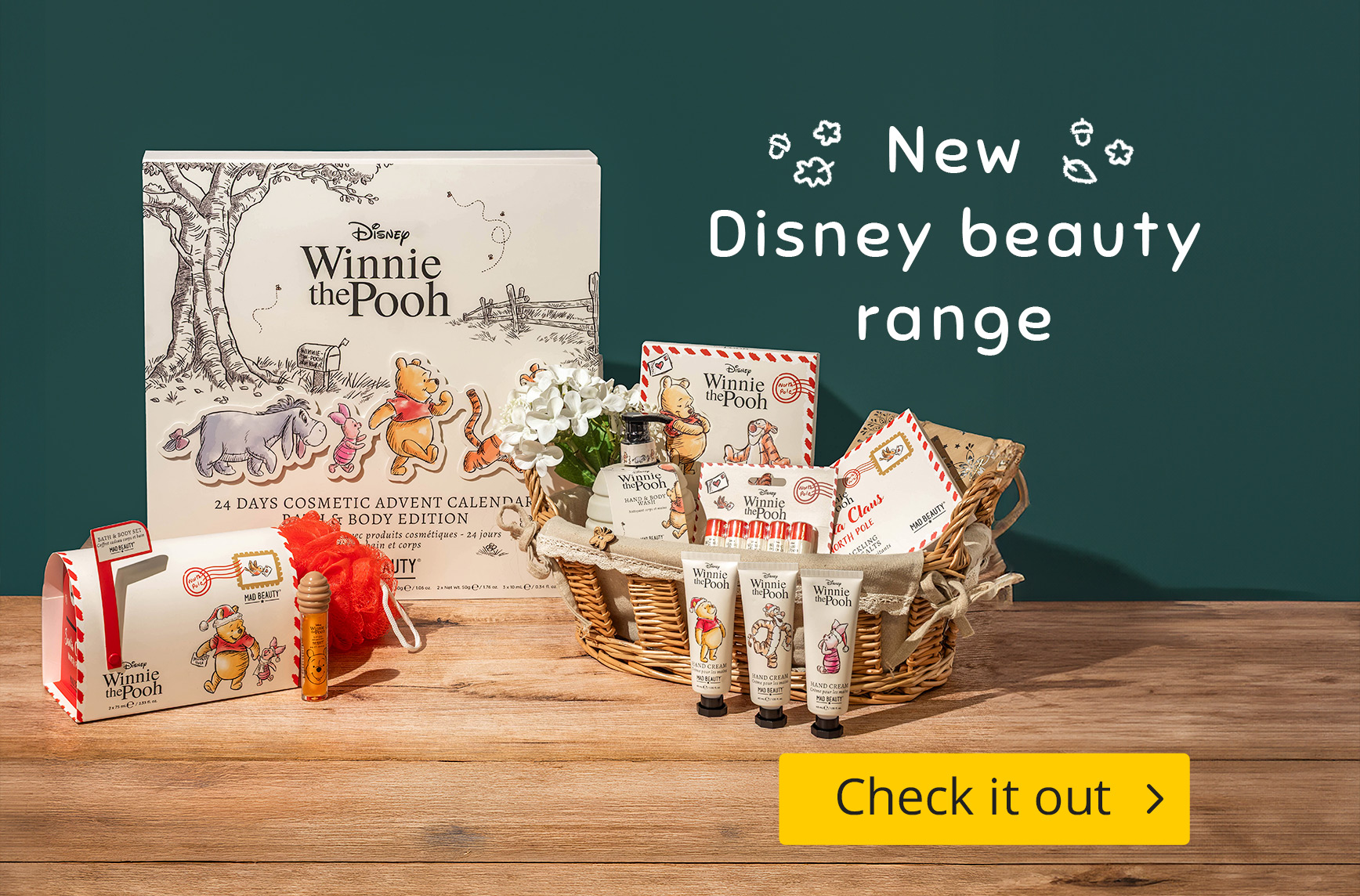 Set with Winnie the Pooh cosmetics on a wooden table: hand creams, shower gel, lip oil, bath sponge and an advent calendar featuring Pooh, Piglet and Eeyore. Text: “New Disney Cosmetics”, yellow button “Check it out”.