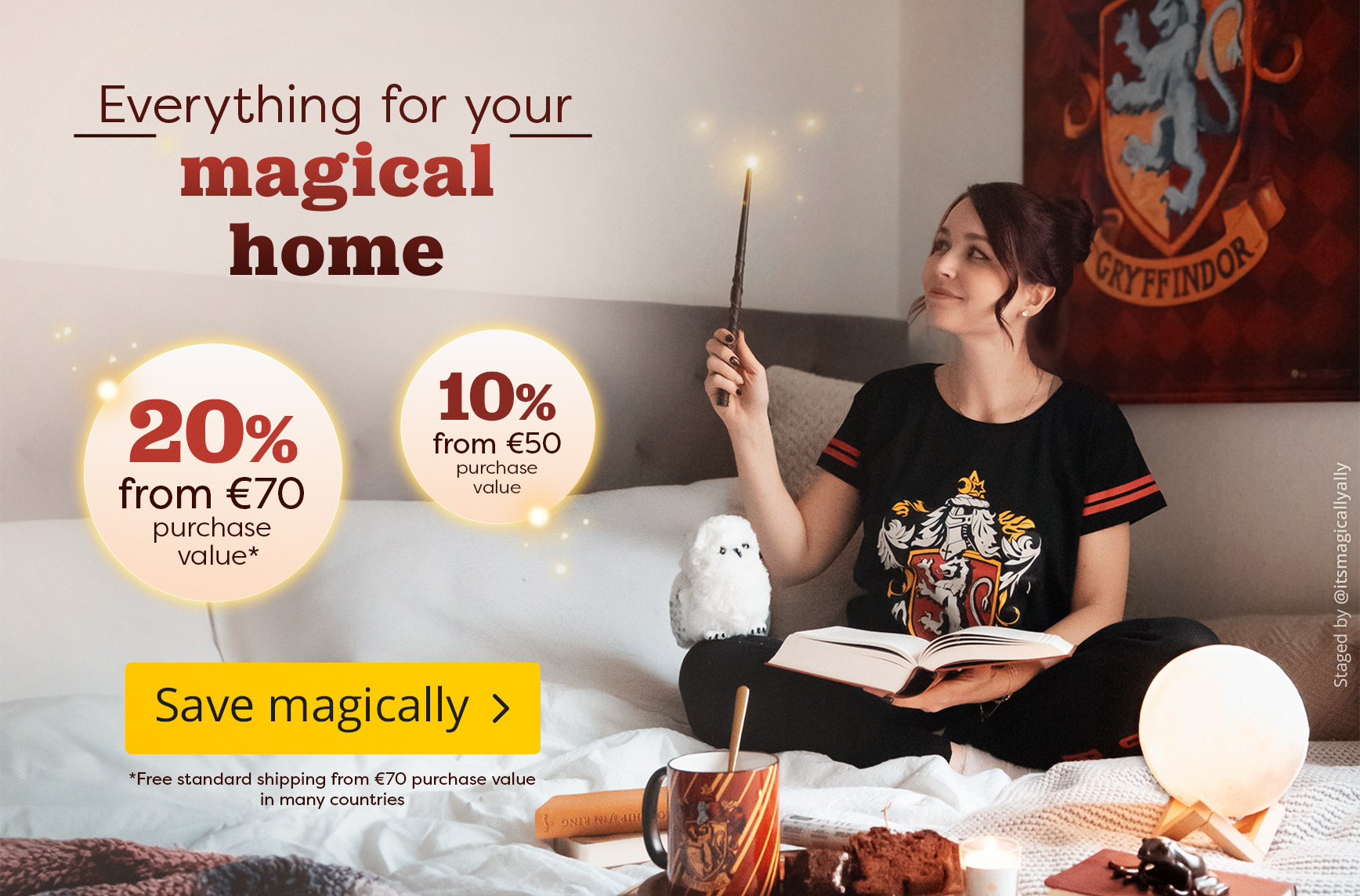Woman in a Gryffindor pyjamas set sitting comfortably on a bed, holding a glowing wand and reading a book. An owl figure, a Gryffindor mug and magical décor are placed on the bed. Text: “Everything for your magical home, 20 % off from €70, 10 % off from €