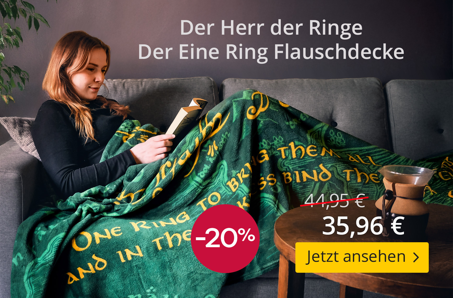 Frau liest auf dem Sofa und ist in eine grüne Flauschdecke mit goldgelber Inschrift aus Der Herr der Ringe gehüllt. Text: Der Herr der Ringe – Der Eine Ring Flauschdecke – 20 % Rabatt – 35,96 € statt 44,95 € – Jetzt ansehen. Elbenwald-Produktgrafik.
