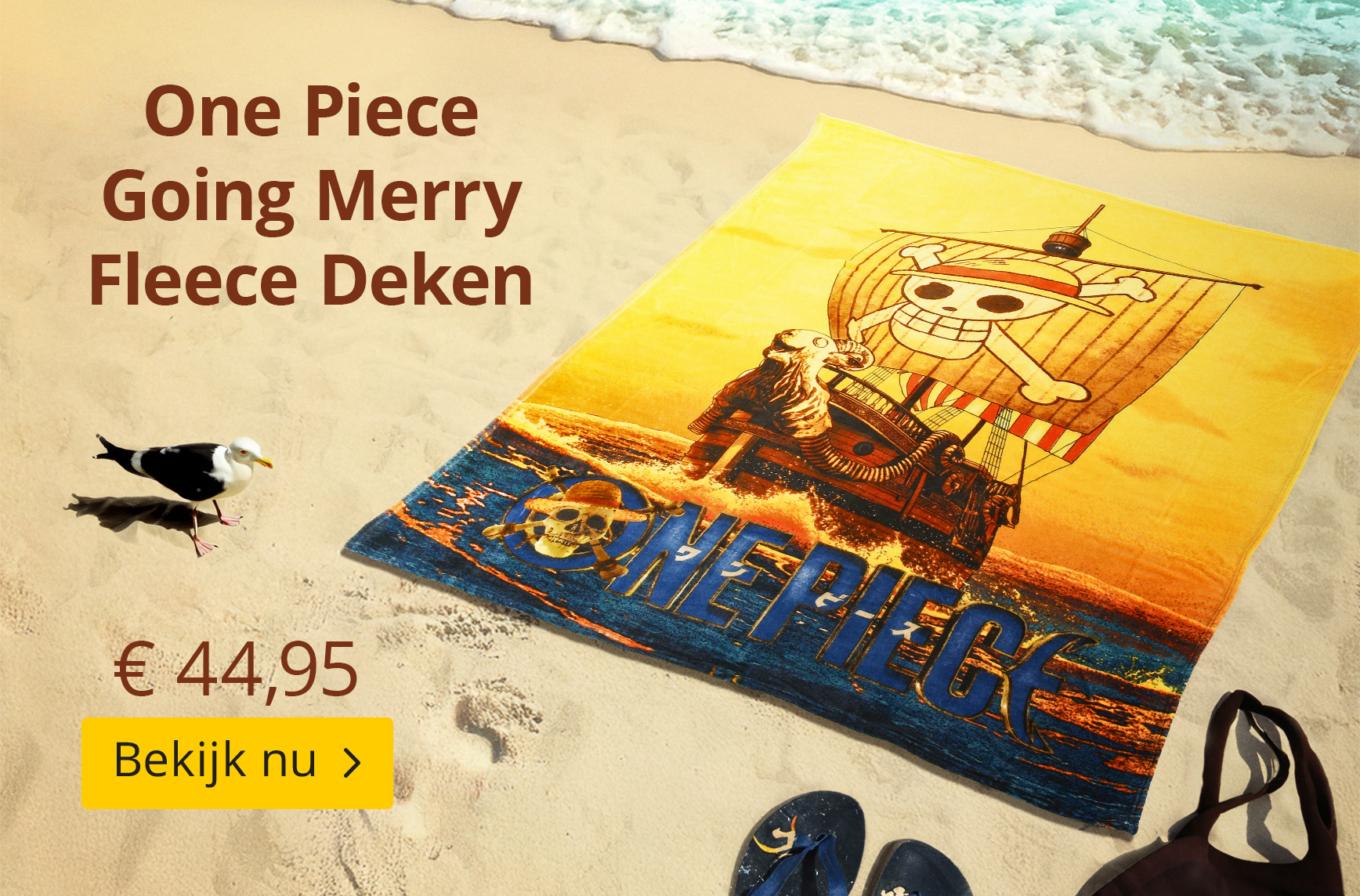 One Piece fleece deken met Going Merry-motief ligt op het strand in het zand. Ontwerp toont het piratenschip van de Straw Hats. Tekst: One Piece Going Merry Fleece Deken – €44,95 – Bekijk nu. Elbenwald-productgrafiek.