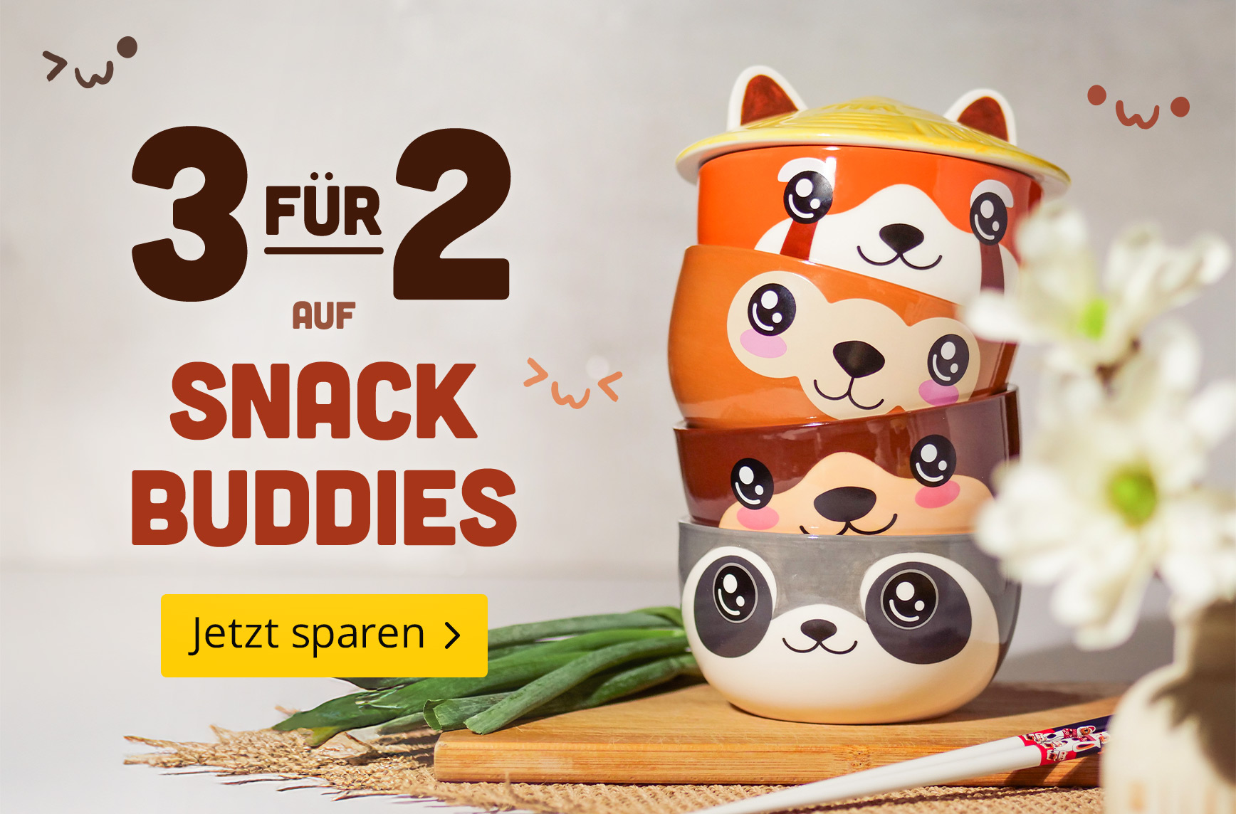 Vier bunte Snackschalen mit niedlichen Tiergesichtern übereinandergestapelt auf einem Küchentisch. Text: "3 für 2 auf Snack Buddies – Jetzt sparen."